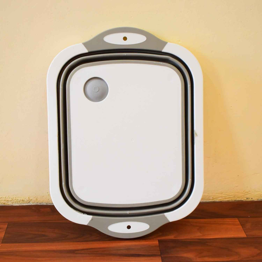 Collapsible cutting board with dish tub basket function, used for washing dishes in a kitchen sink.