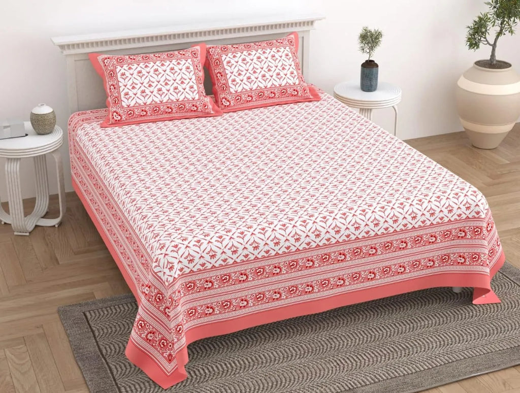 Red and white floral print cotton queen bedsheet with matching pillow covers on bed