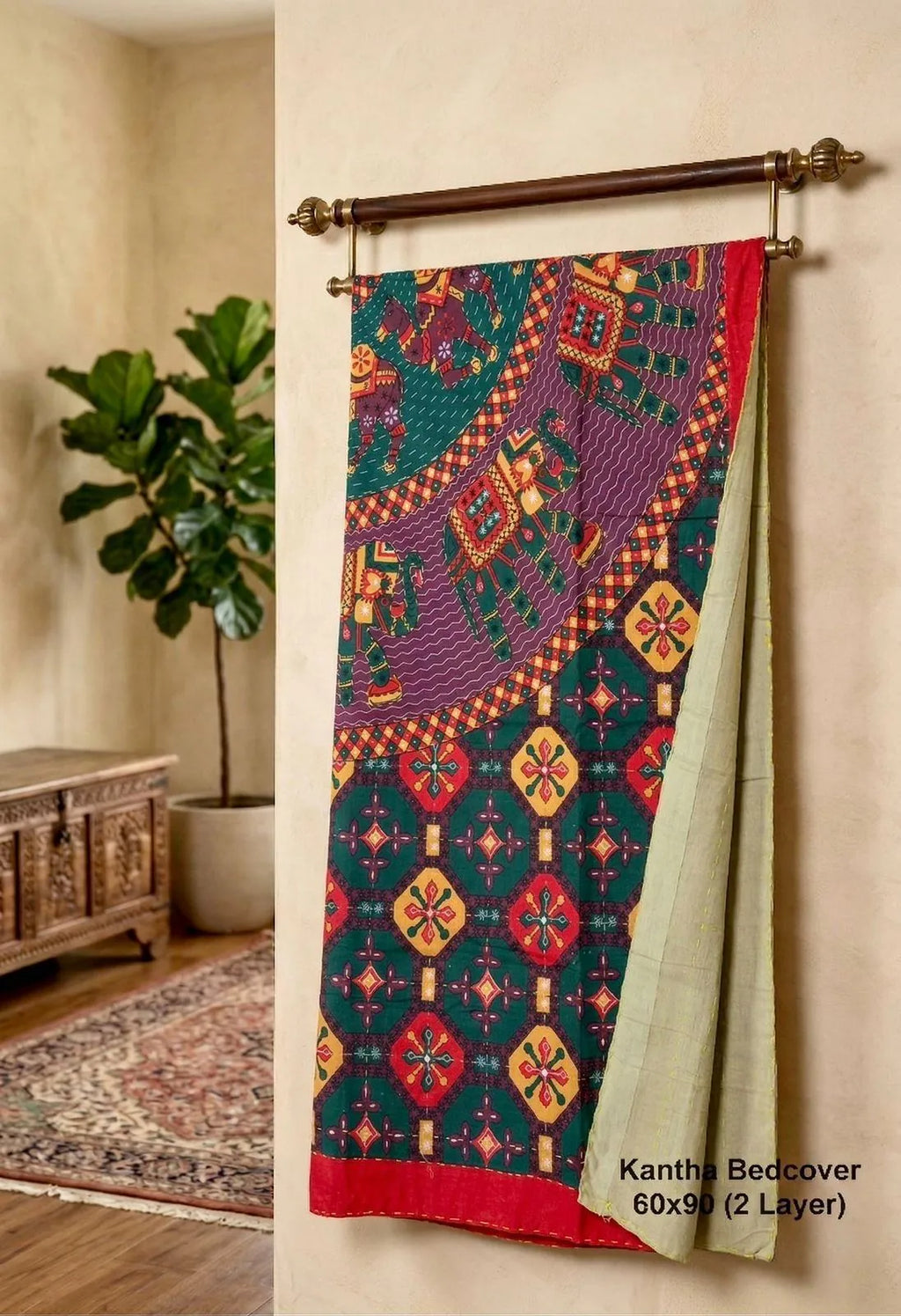 Green and red Jaipuri printed single bed Kantha bedcover hanging on a wooden rod