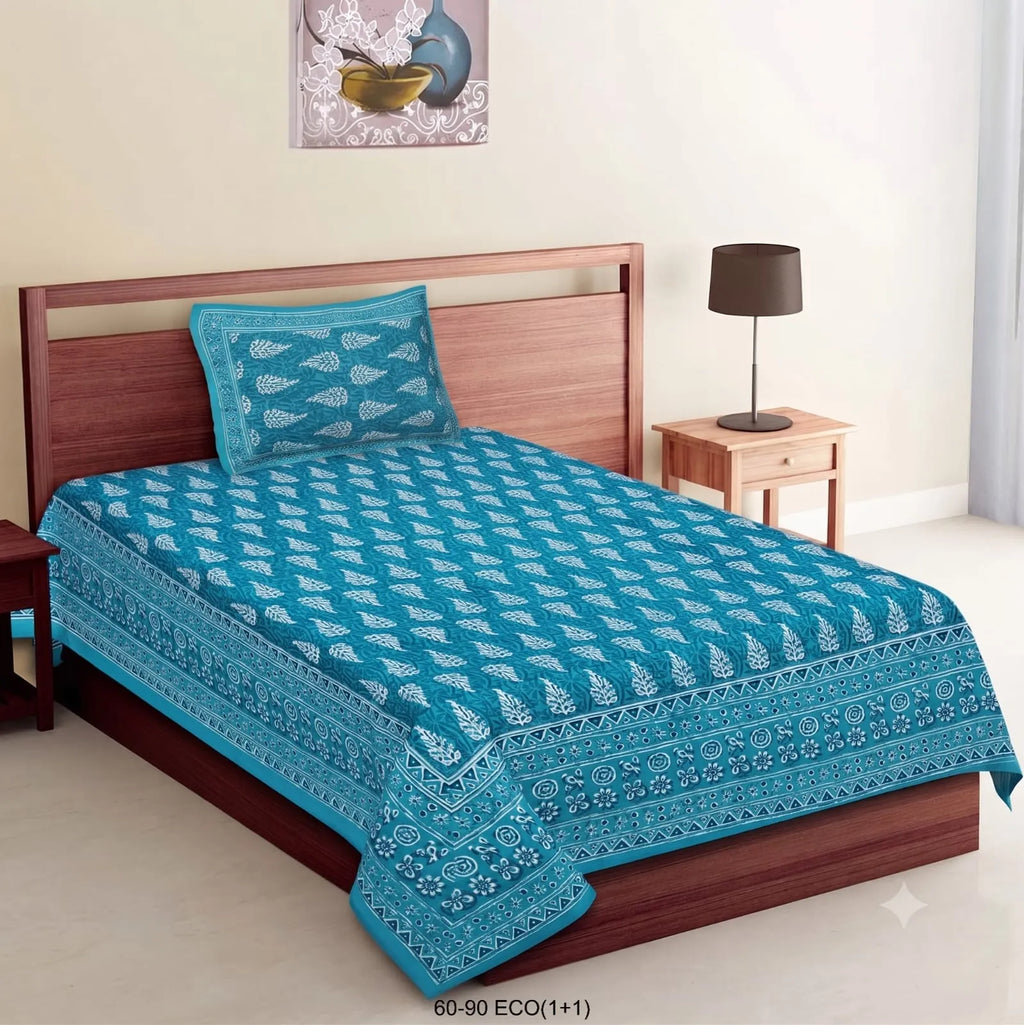 Teal blue cotton single bedsheet with white floral leaf print and matching pillow cover on a wooden bed