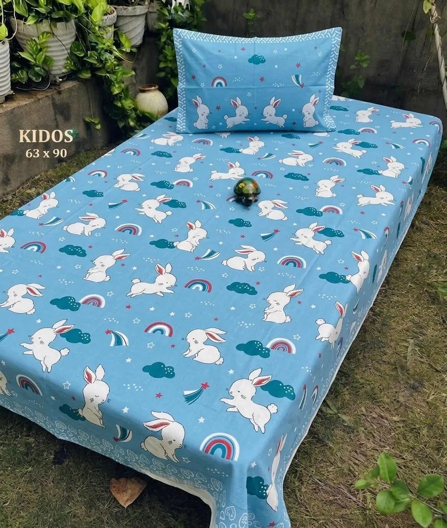 Blue single bedsheet with white bunny and rainbow print and matching pillow cover on bed