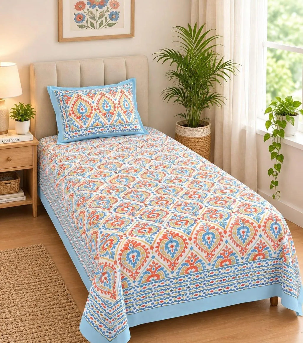 Single bedsheet in blue paisley print with matching pillow cover on bed