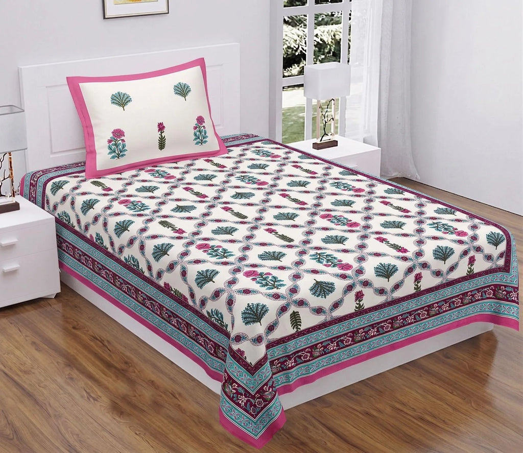 Pink and teal floral dabu print single cotton bedsheet on bed with matching pillow cover