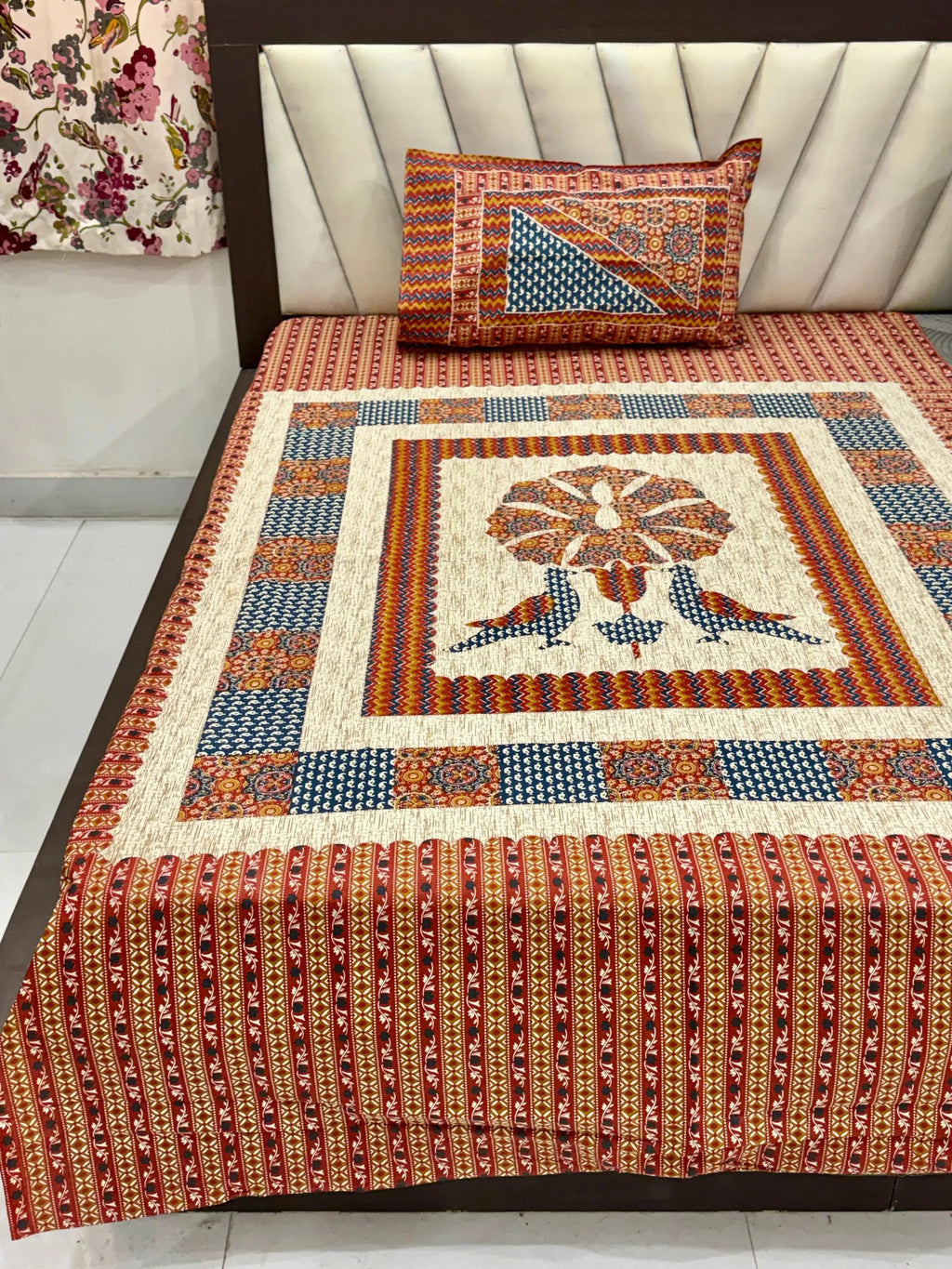 Red and blue Barmeri print single bedsheet with bird motif and matching pillow cover on bed