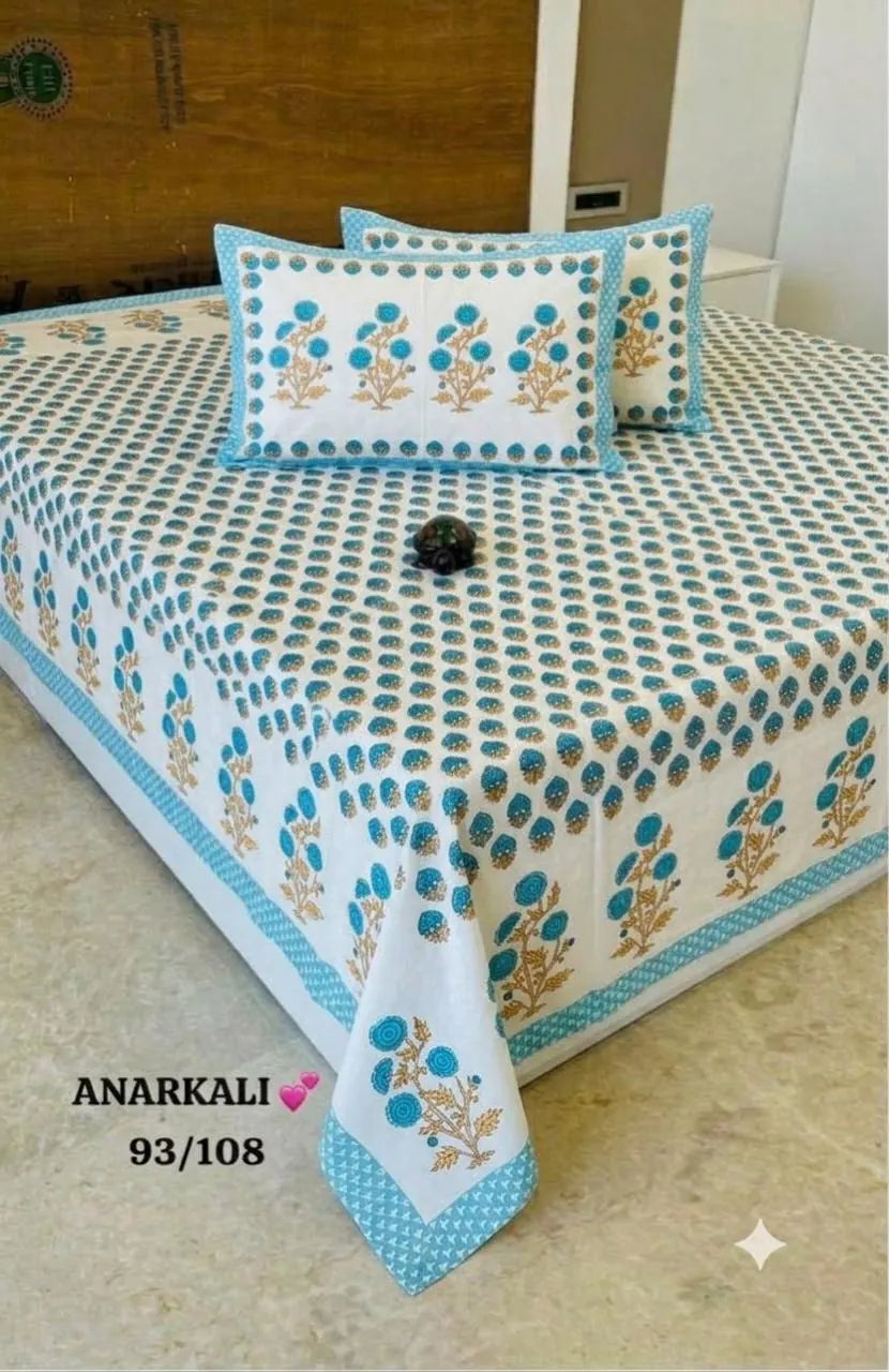 White cotton super king bedsheet with blue floral handblock print and matching pillow covers on bed