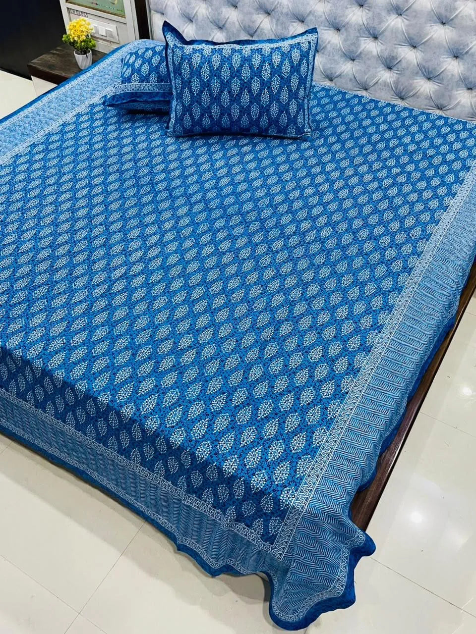 Blue leaf print pure cotton super king bedsheet with matching pillow covers on bed