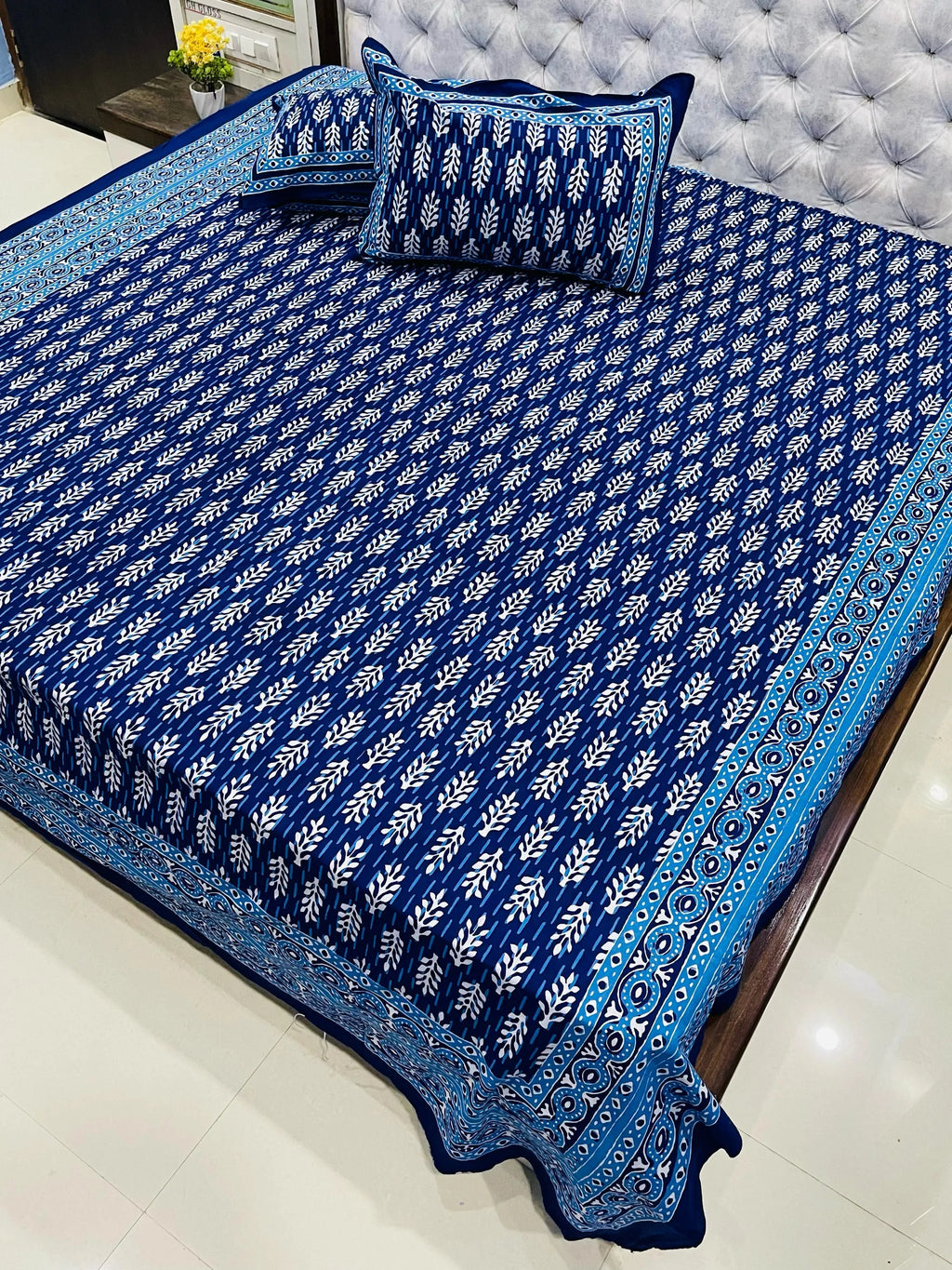 Blue leaf print pure cotton super king bedsheet with matching zipped pillow covers on bed