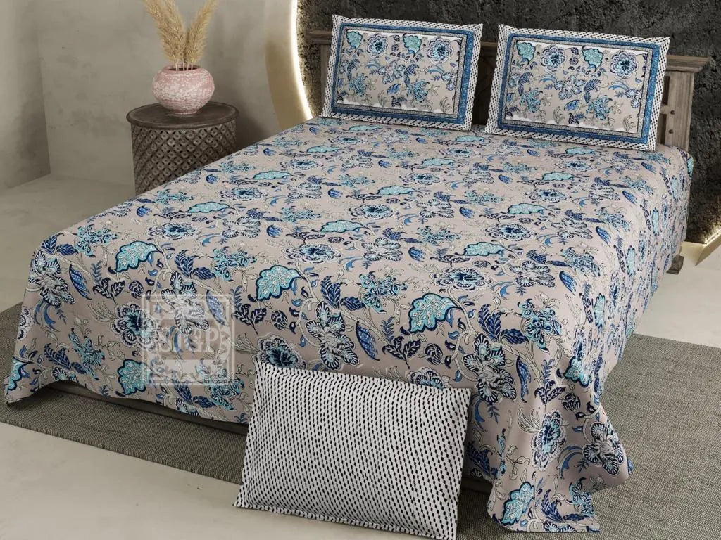 Beige super king cotton bedsheet with blue floral print and two matching pillow covers on bed
