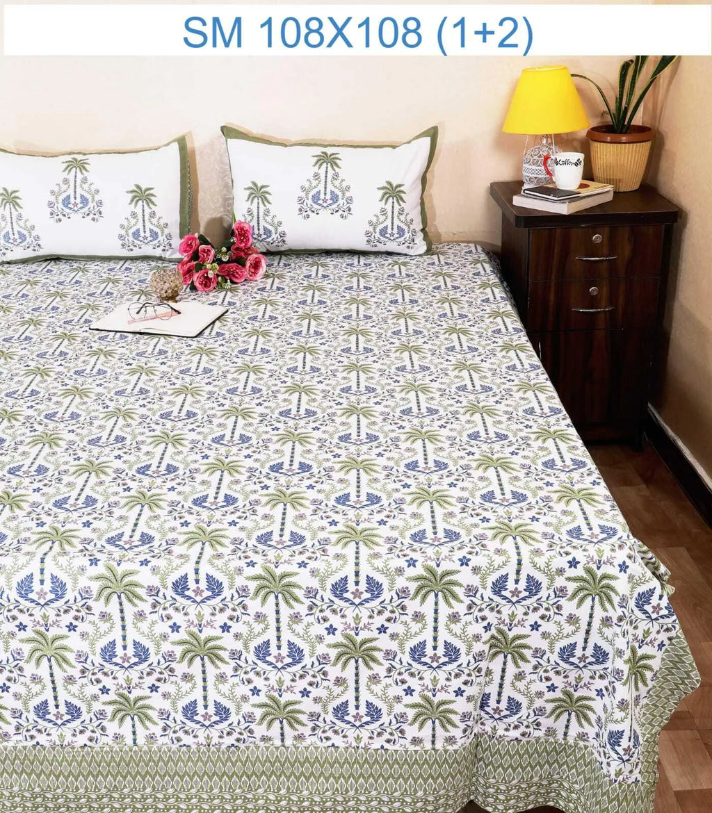Green and blue palm tree print cotton bedsheet with two matching pillow covers on a bed
