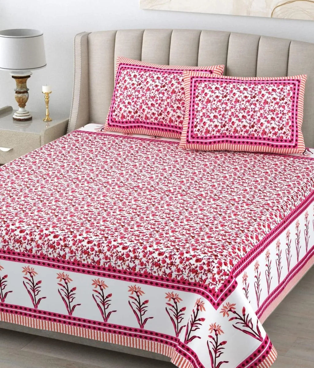 Pink floral print pure cotton bedsheet with matching pillow covers on bed