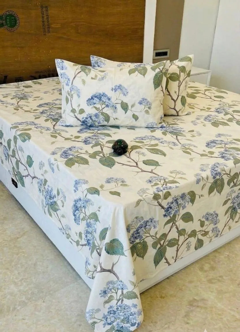 White and blue floral print cotton super king bedsheet on a bed with two pillows