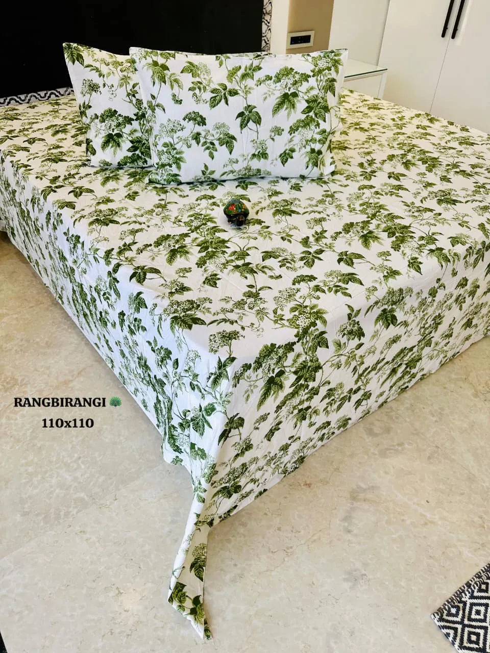 White and green leaf print pure cotton super king bedsheet with matching pillow covers on bed
