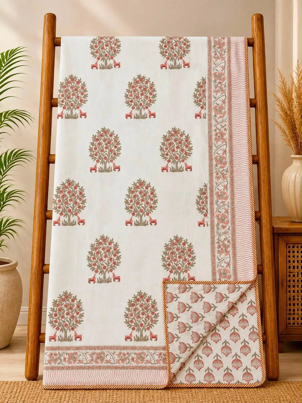 Peach floral hand block printed cotton dohar draped over wooden ladder
