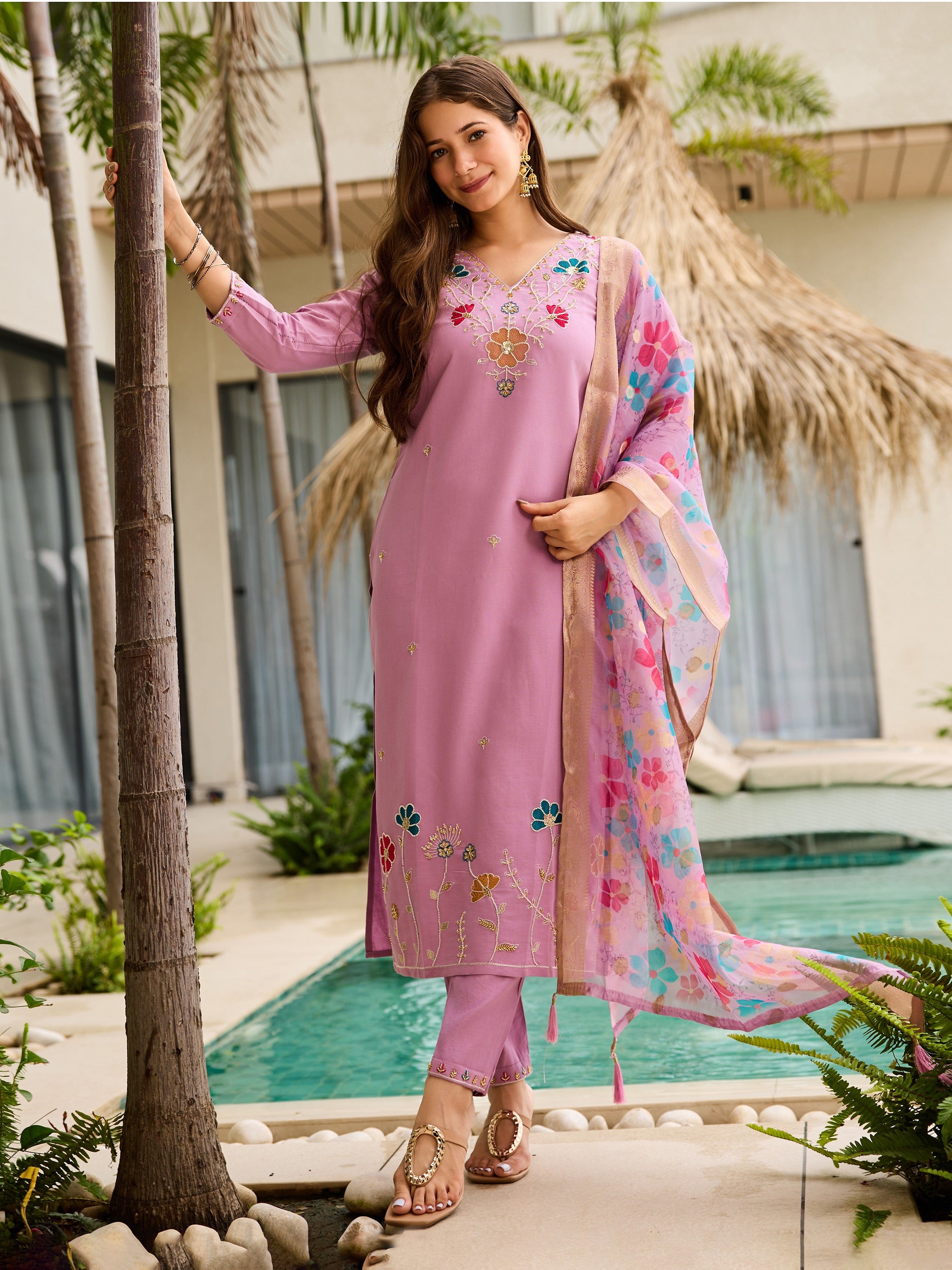 Model in serene lavender embroidered viscose kurta set by a tropical pool, full length.