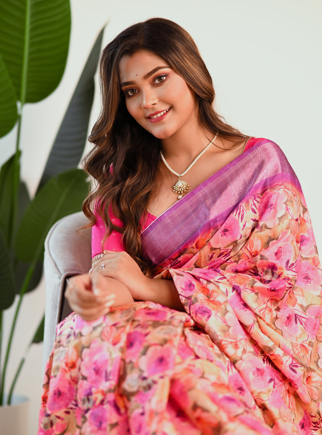 Vibrant purple floral print saree with intricate flower patterns, draped elegantly to show its texture.