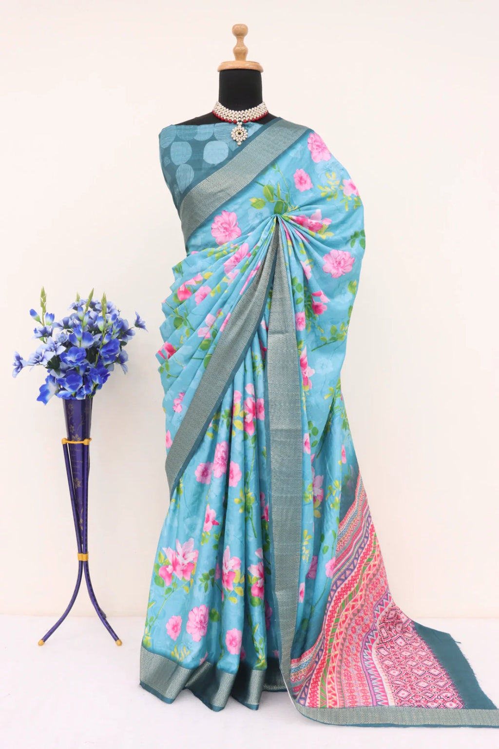 Close-up of the intricate digital prints and traditional floral motifs on light blue fabric