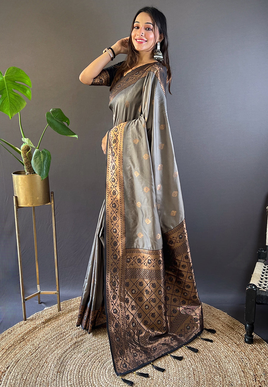 Close-up of the intricate gold zari woven floral motifs on the soft grey silk fabric