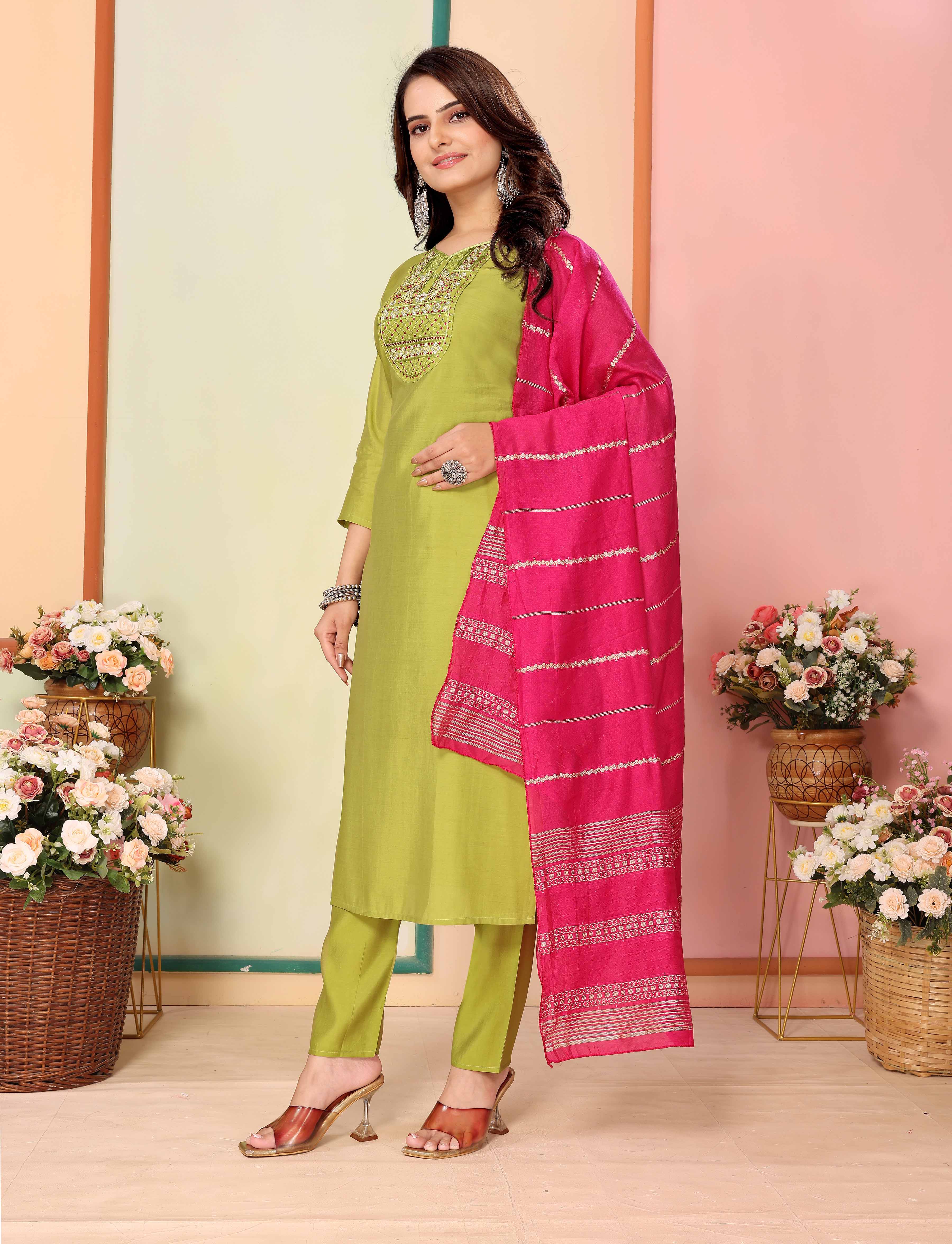 Side profile of model posing in lime green silk kurta set, with pink dupatta elegantly draped, emphasizing the comfortable fit and embroidery from TRENDBUY.