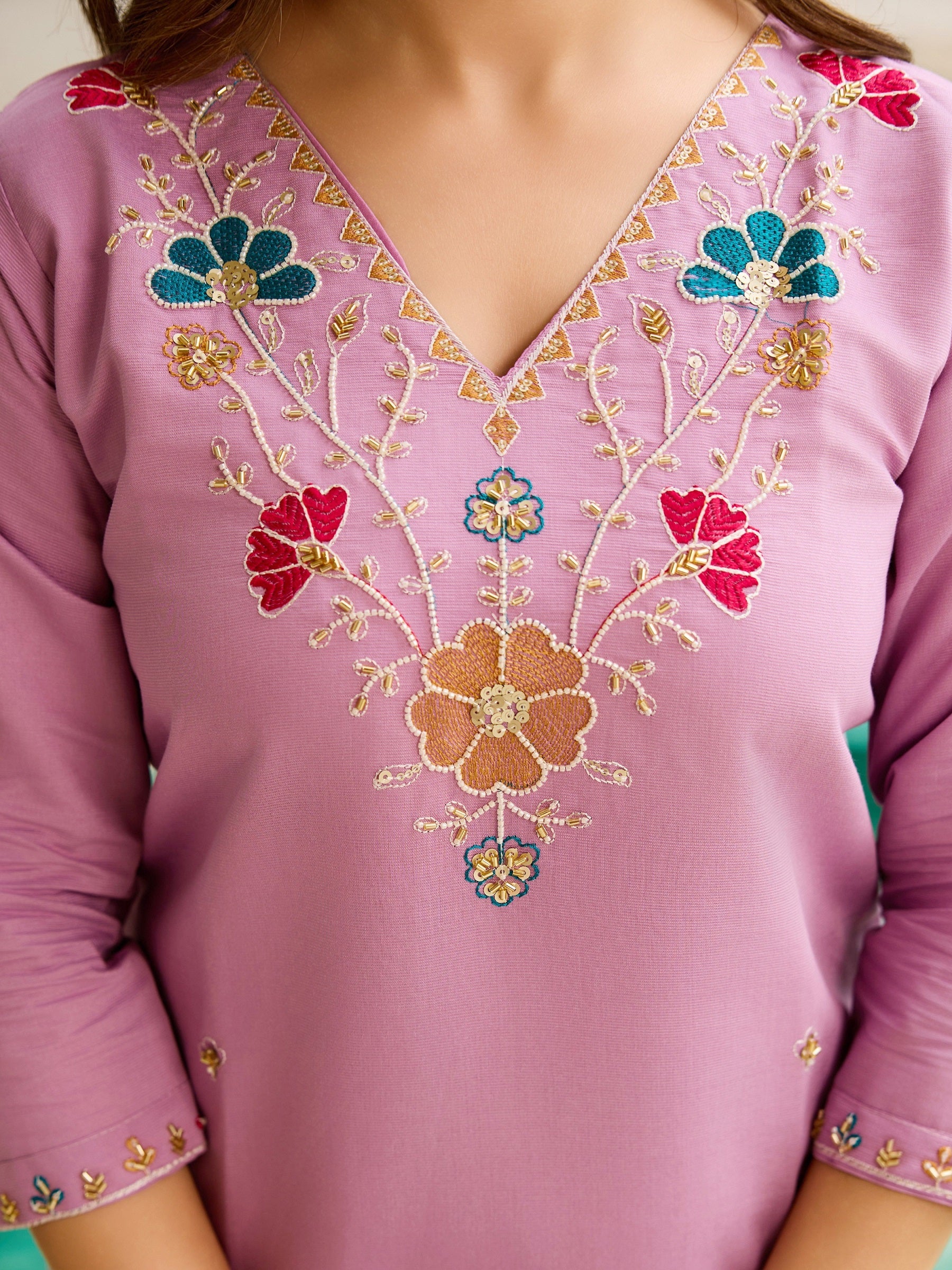 Detailed close-up of the delicate floral embroidery and beadwork on the lavender kurta's V-neck.
