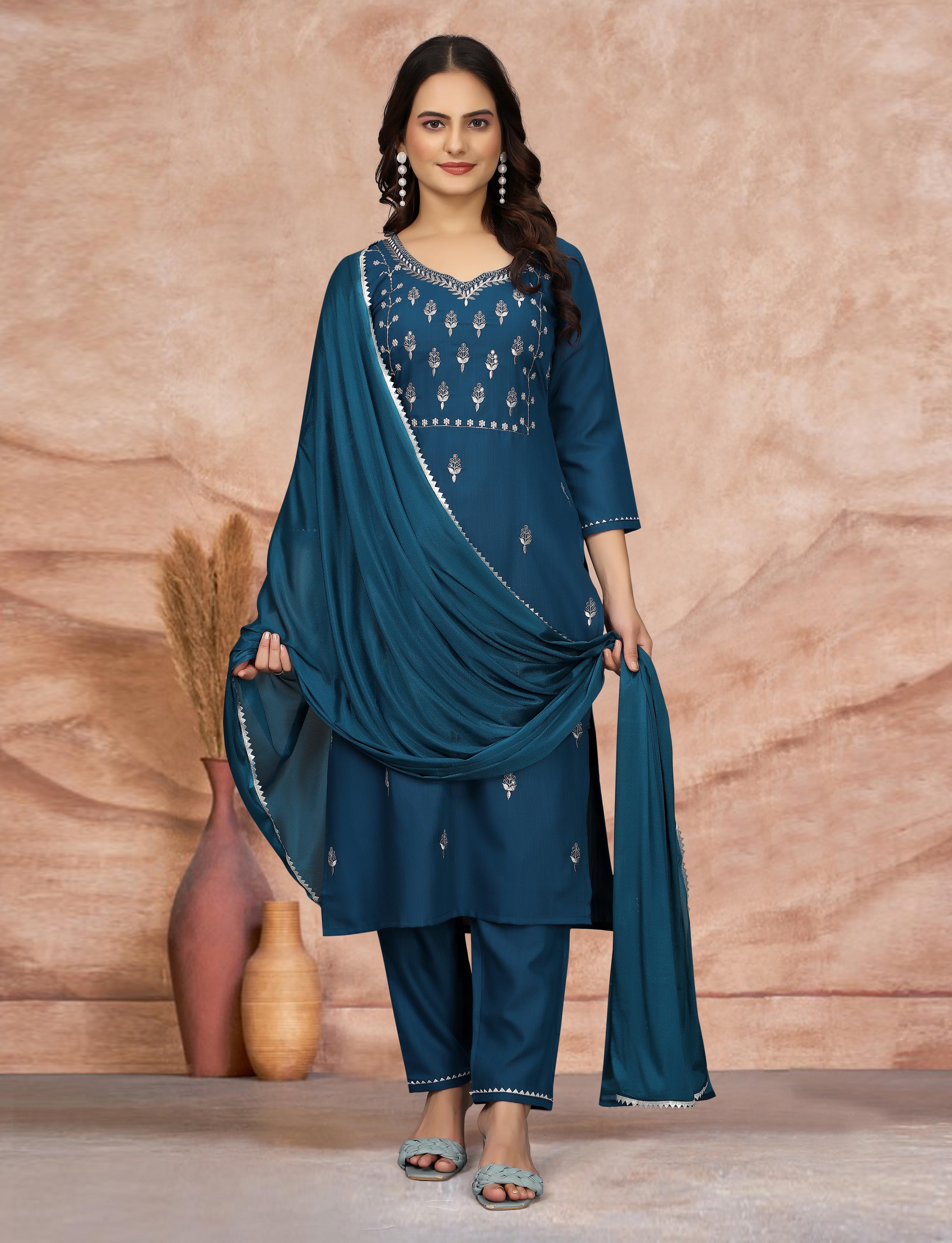 Stylish woman in teal blue ethnic kurti set, gracefully holding silk dupatta.