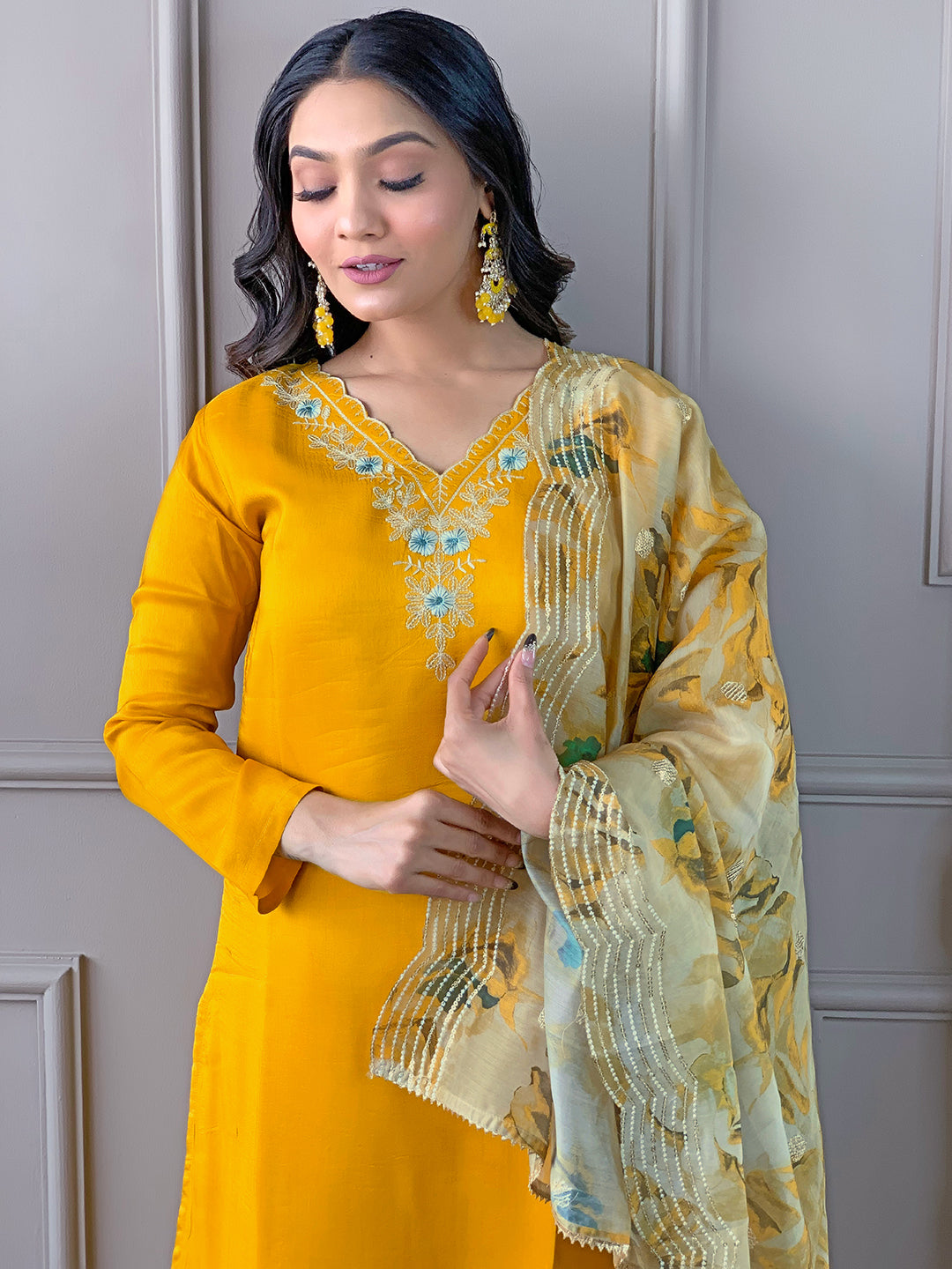 Model in TRENDBUY D468 Yellow kurti set, looking down thoughtfully and gently holding the floral dupatta.