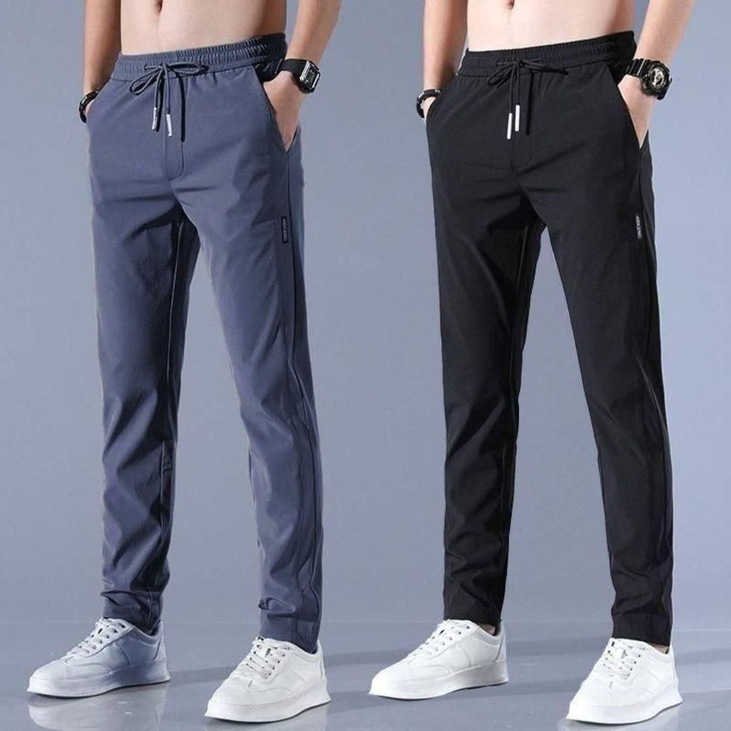 Two pairs of jogger pants in gray and black on a gray background