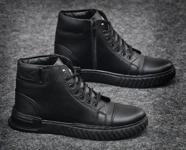 Black high-top boots on a textured gray background