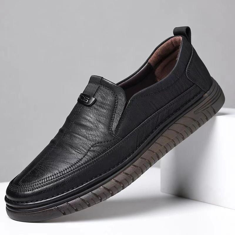 Black leather shoe on a gray background