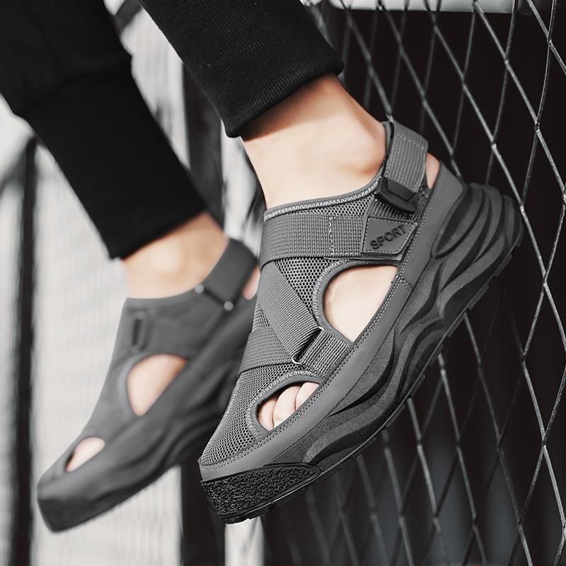 Gray sandals worn by a person against a black and white geometric background