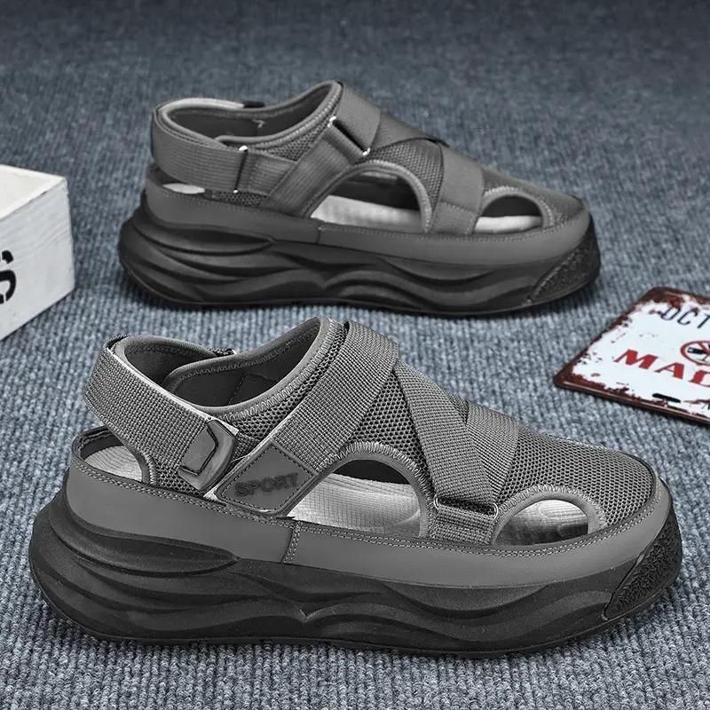 Gray sandals on a textured surface with a box and sign in the background
