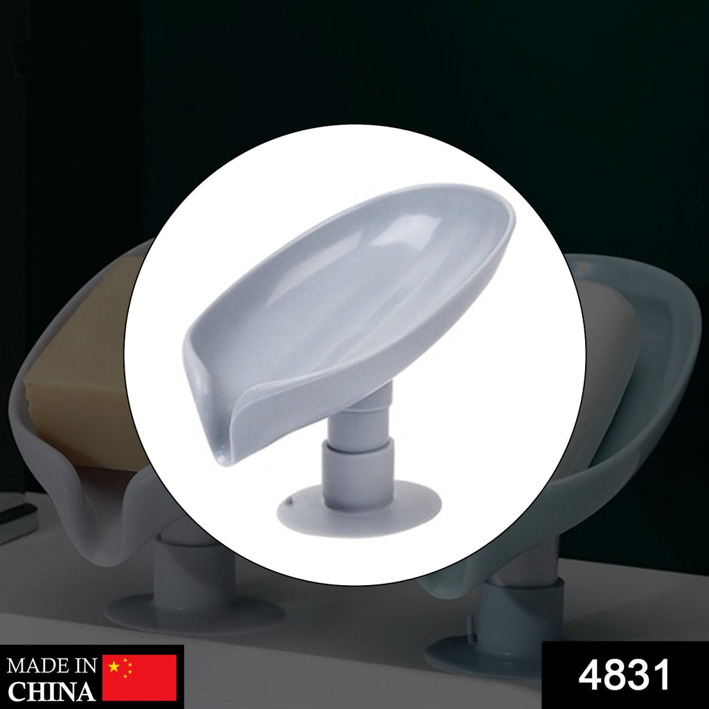 Green leaf-shaped self-draining soap dish in a bathroom, holding a bar of soap