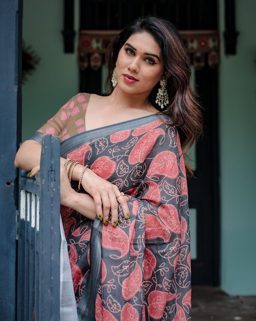 Woman posing in an earthy olive and charcoal gray Pure Linen Saree with coral leaf prints.