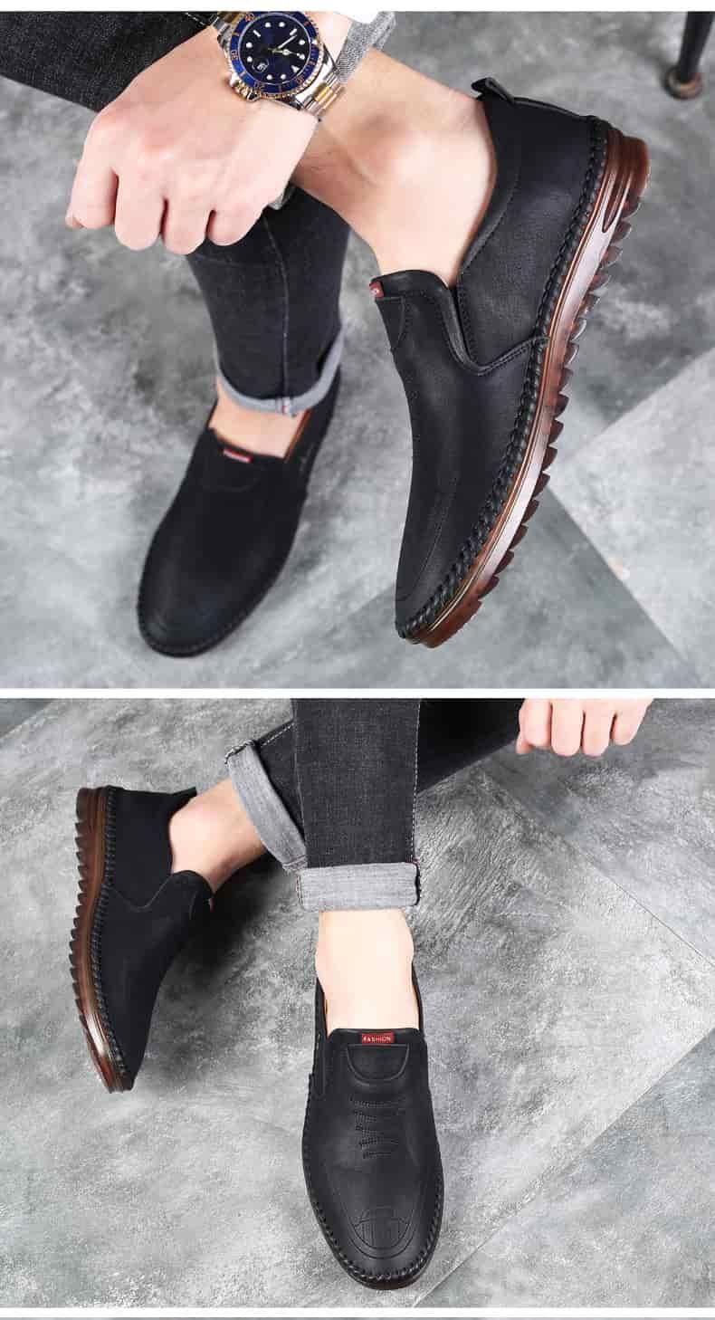 Black loafers worn by a person on a gray concrete floor