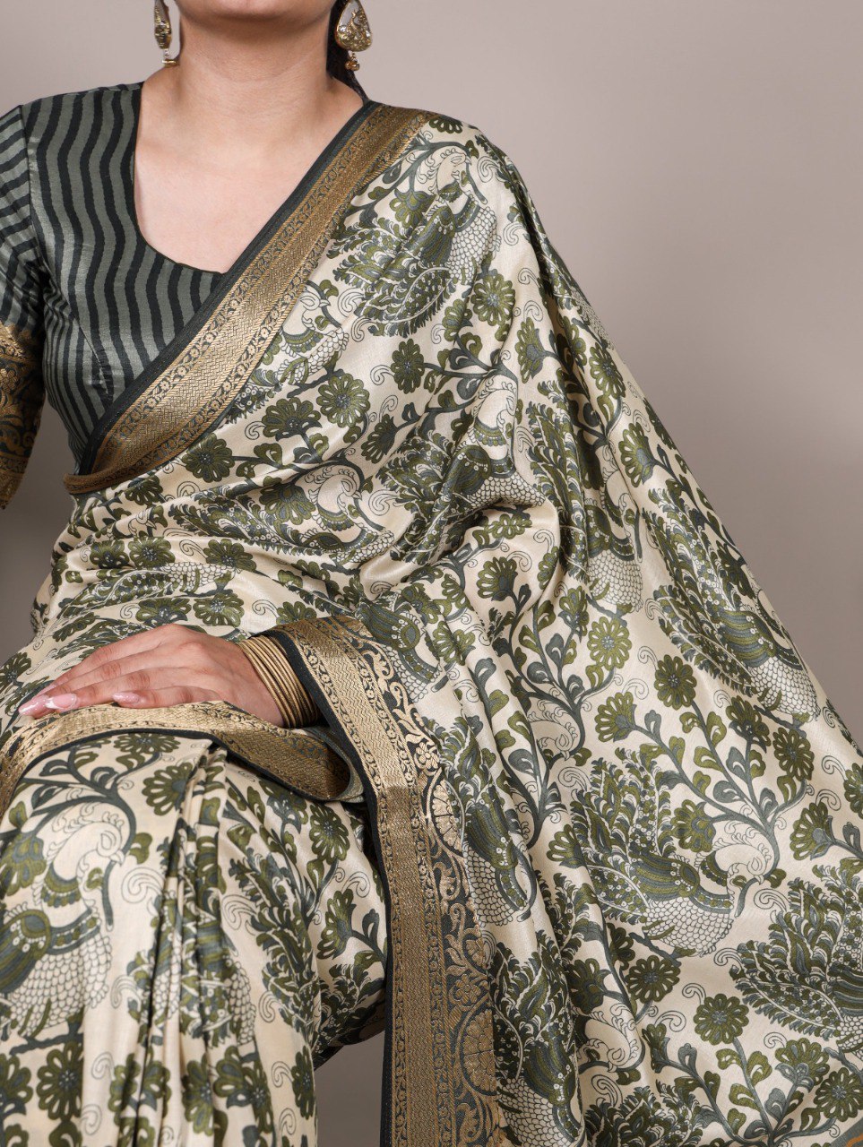 Close-up of TRENDBUY model's arm and hands, showcasing the delicate print and lustrous border of a mint green Tasar silk saree.