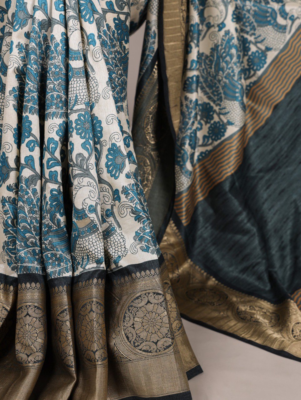Detailed shot of the sky blue printed Tasar silk saree fabric, showing the traditional motifs and the intricate golden viscose border.