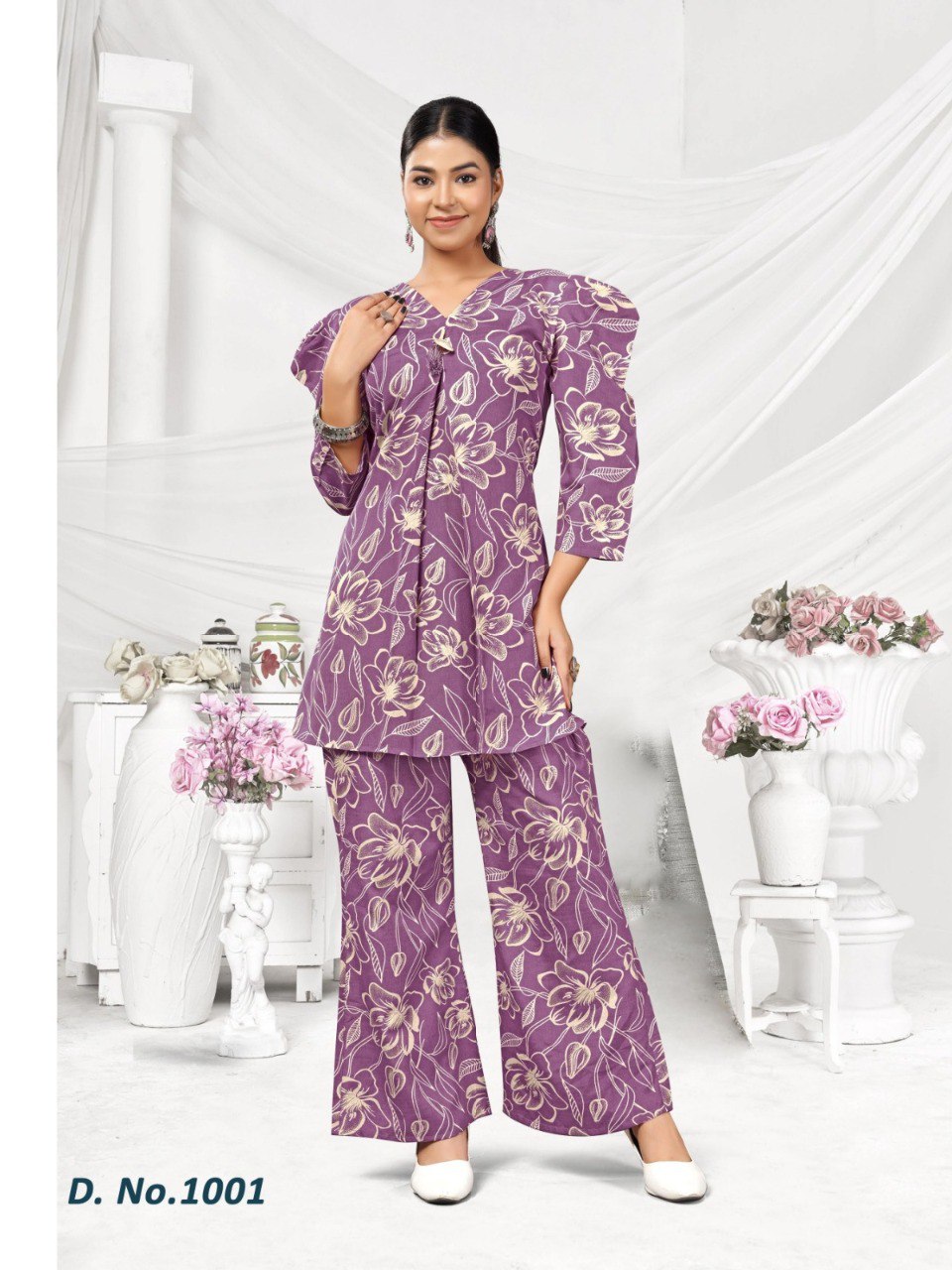 Model wearing a purple floral rayon co-ord set with a V-neck peplum top and matching wide-leg pants, ideal for summer fashion.