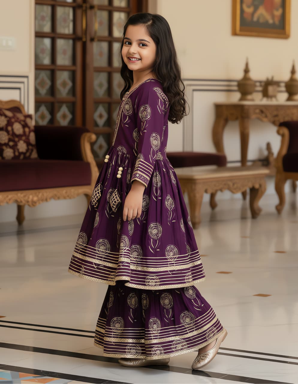 Happy girl in a purple ethnic kurta kediya and sharara set, showing the flared design and gold patterns.