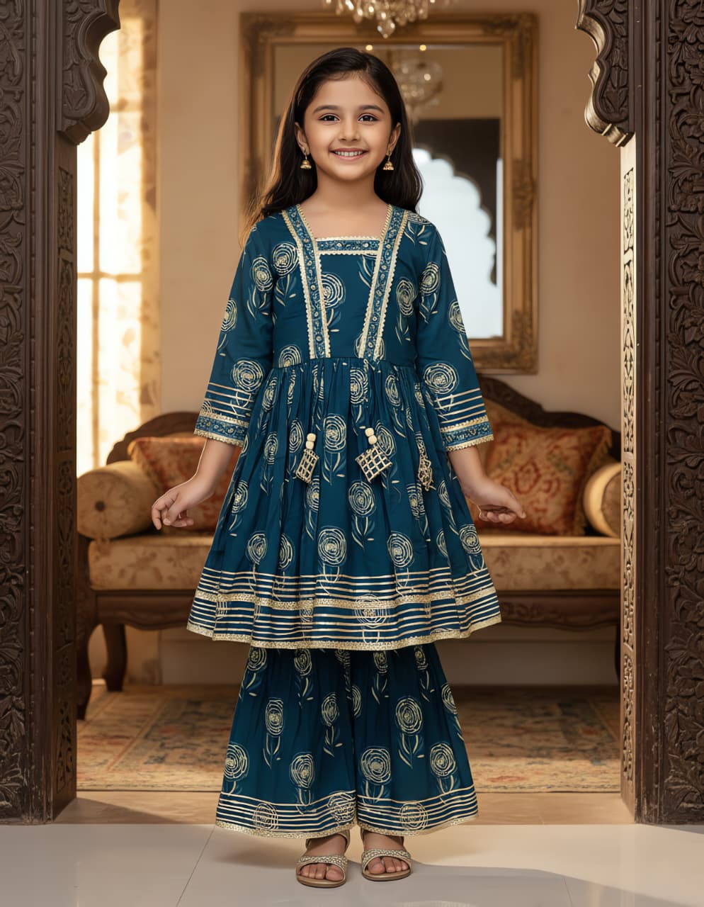Front view of a girl in a complete teal ethnic kurta kediya and sharara set, smiling, highlighting the traditional design.