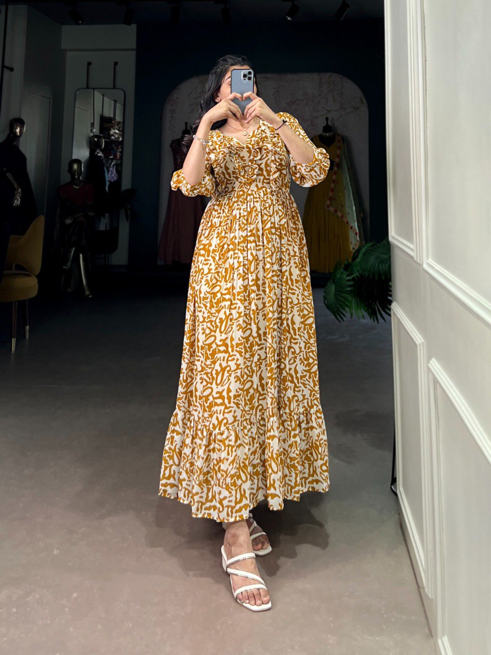 TRENDBUY model posing in a mustard yellow printed georgette maxi frock dress with ruffle neck, full body mirror selfie