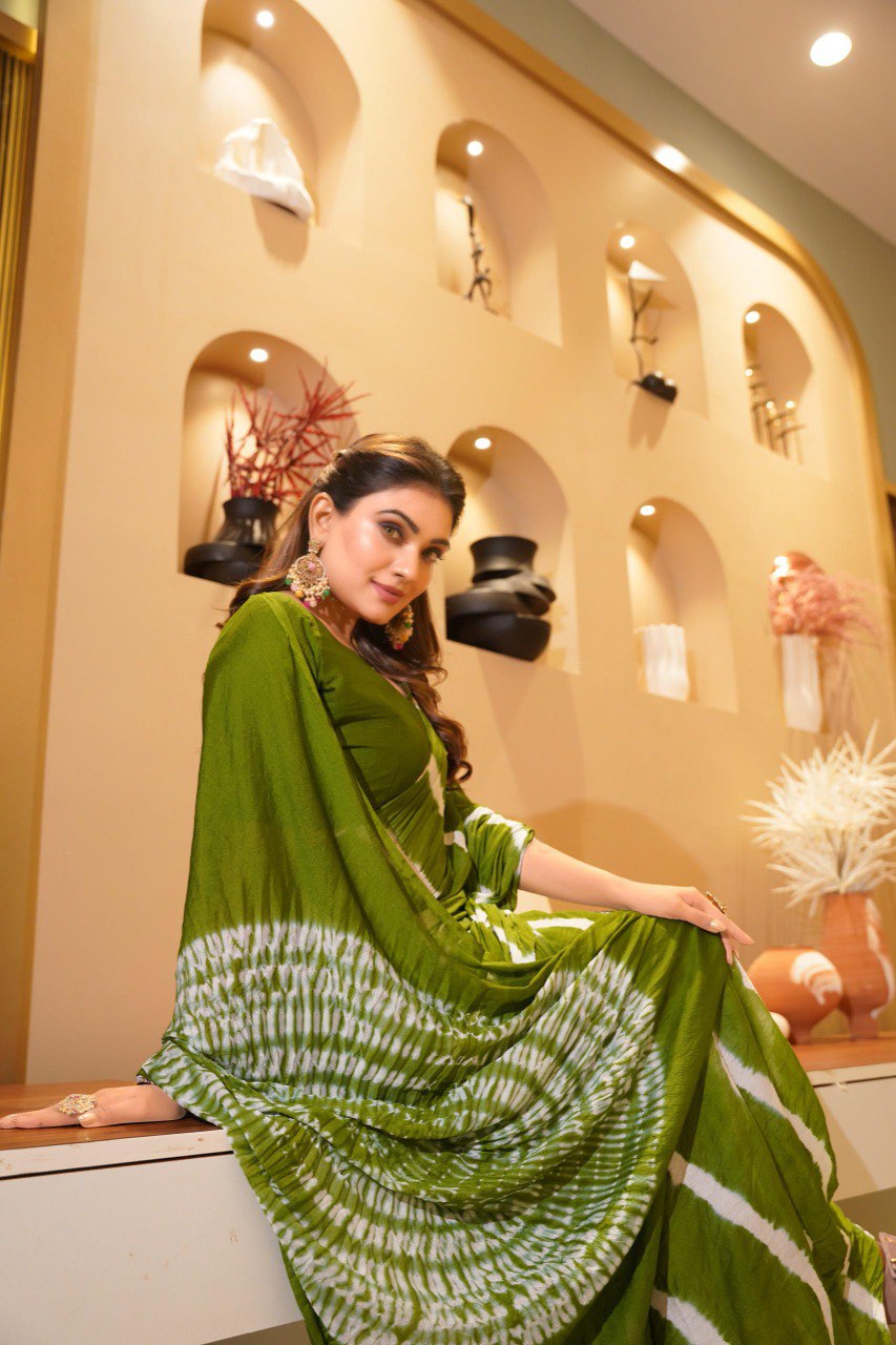 TRENDBUY model in elegant olive green Pure Chinoon Hand Shibori Laheriya saree, seated gracefully.