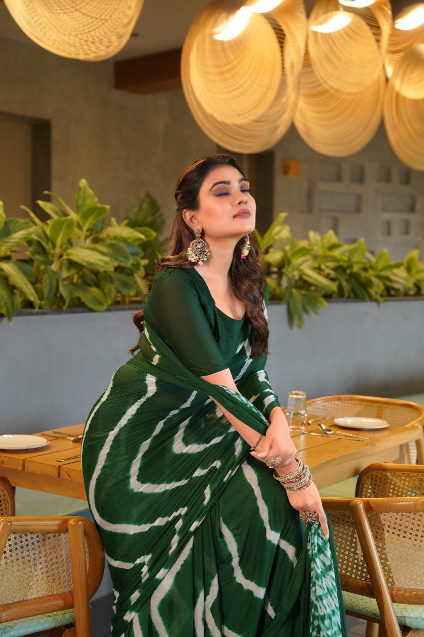 TRENDBUY model holding the pallu of her dark emerald green Pure Chinoon Hand Shibori Laheriya saree.