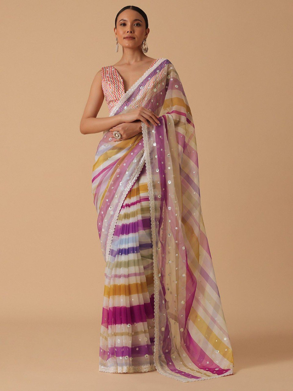 Full shot of model in pink and yellow striped georgette saree, displaying the full drape and elegant fall.