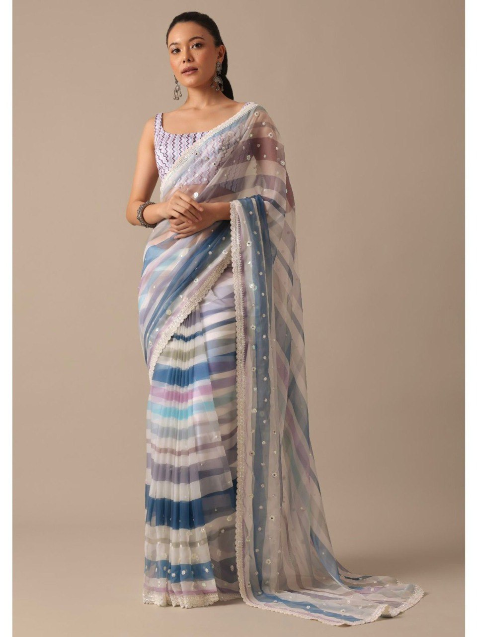 Model posing in blue and purple striped georgette saree, showcasing the graceful drape and detailing.