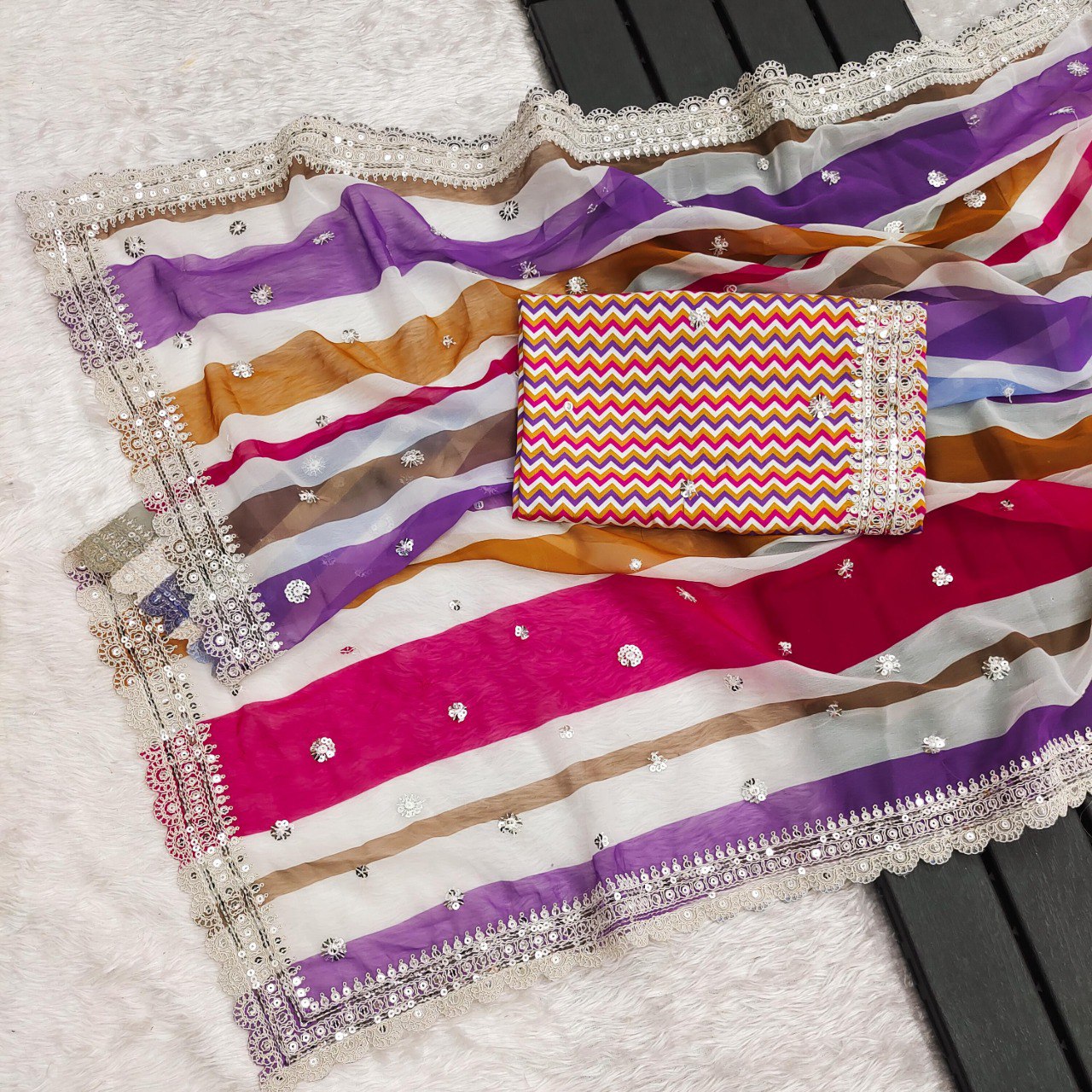 Full flat lay view of the pink and yellow multi-striped georgette saree with its rich colors and detailed cutwork border.