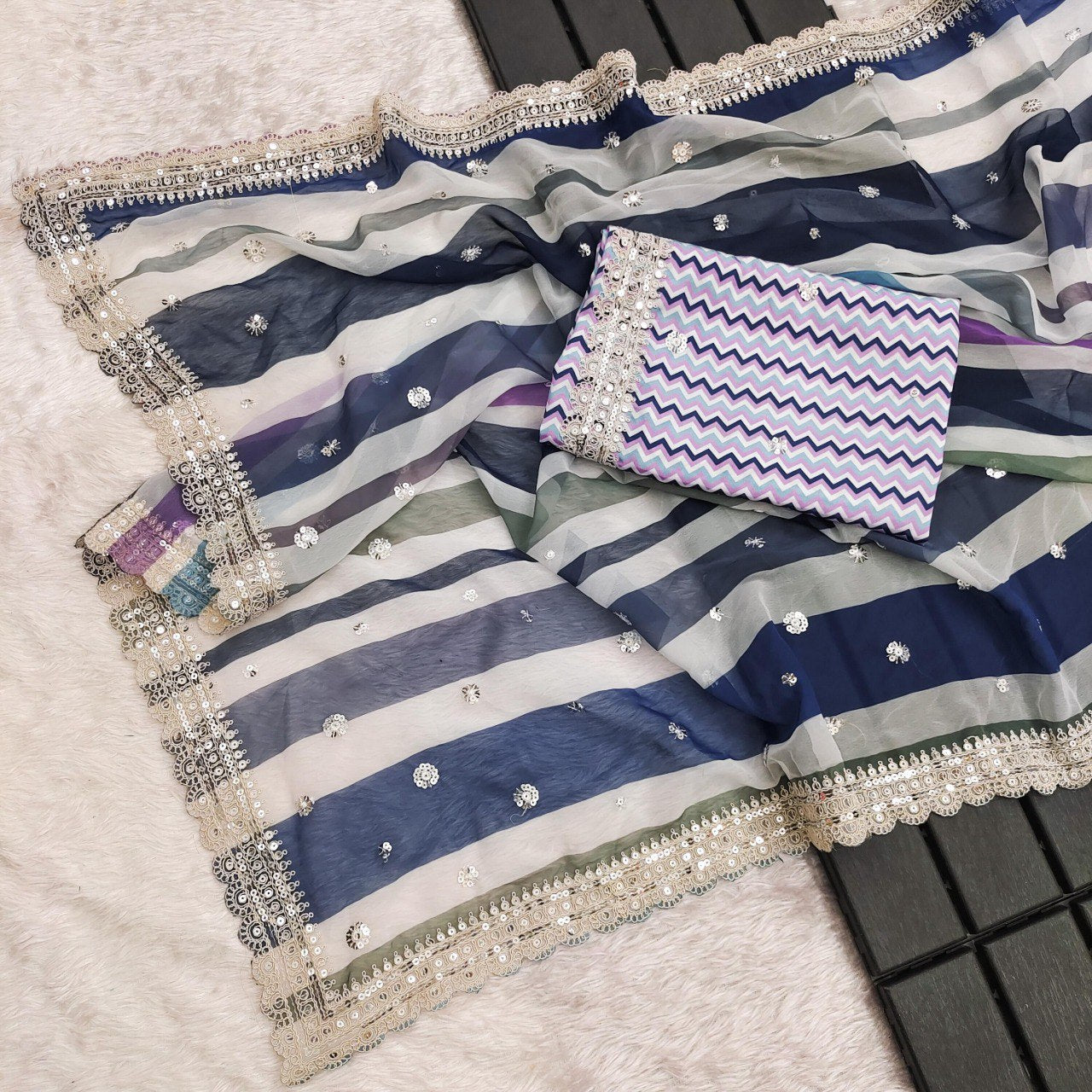 Full flat lay view of the blue and purple multi-striped georgette saree, displaying the fabric, sequins, and border.