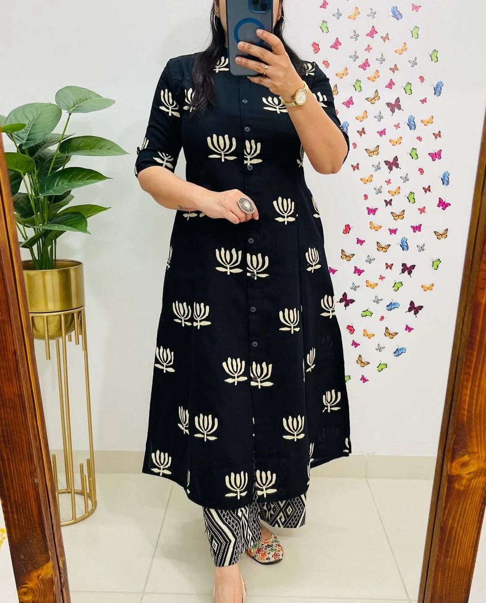 TRENDBUY woman wearing black cotton digital print kurta with lotus motifs and geometric palazzo pants, posing elegantly in a mirror.