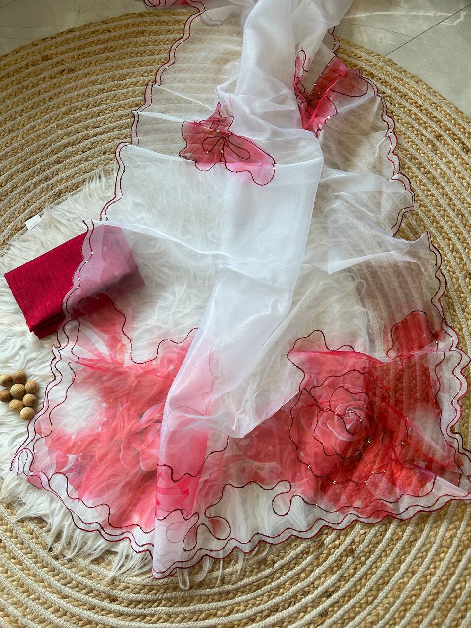 Close-up of the delicate red floral print on translucent white organza fabric