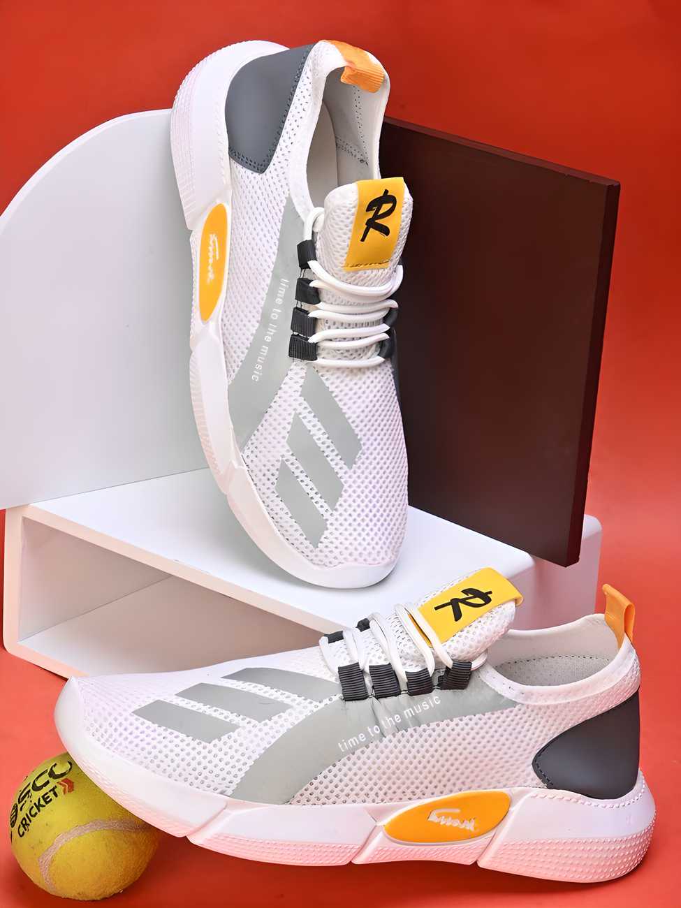 White and gray athletic shoes with orange accents on a red background