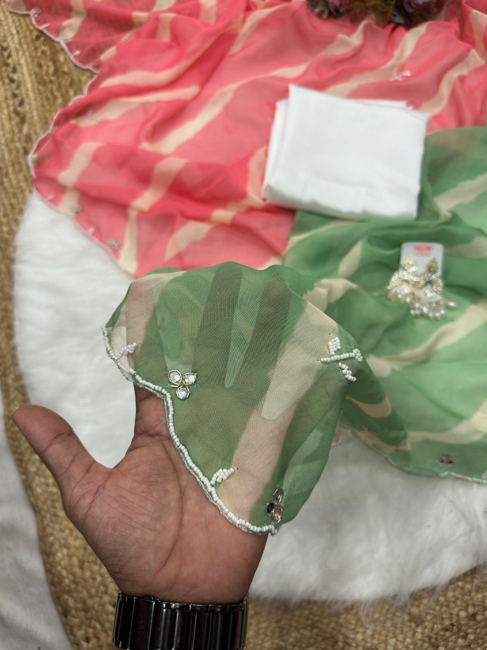 Detailed view of green Lehriya Tebi silk saree border with intricate val moti and mirror embellishments.