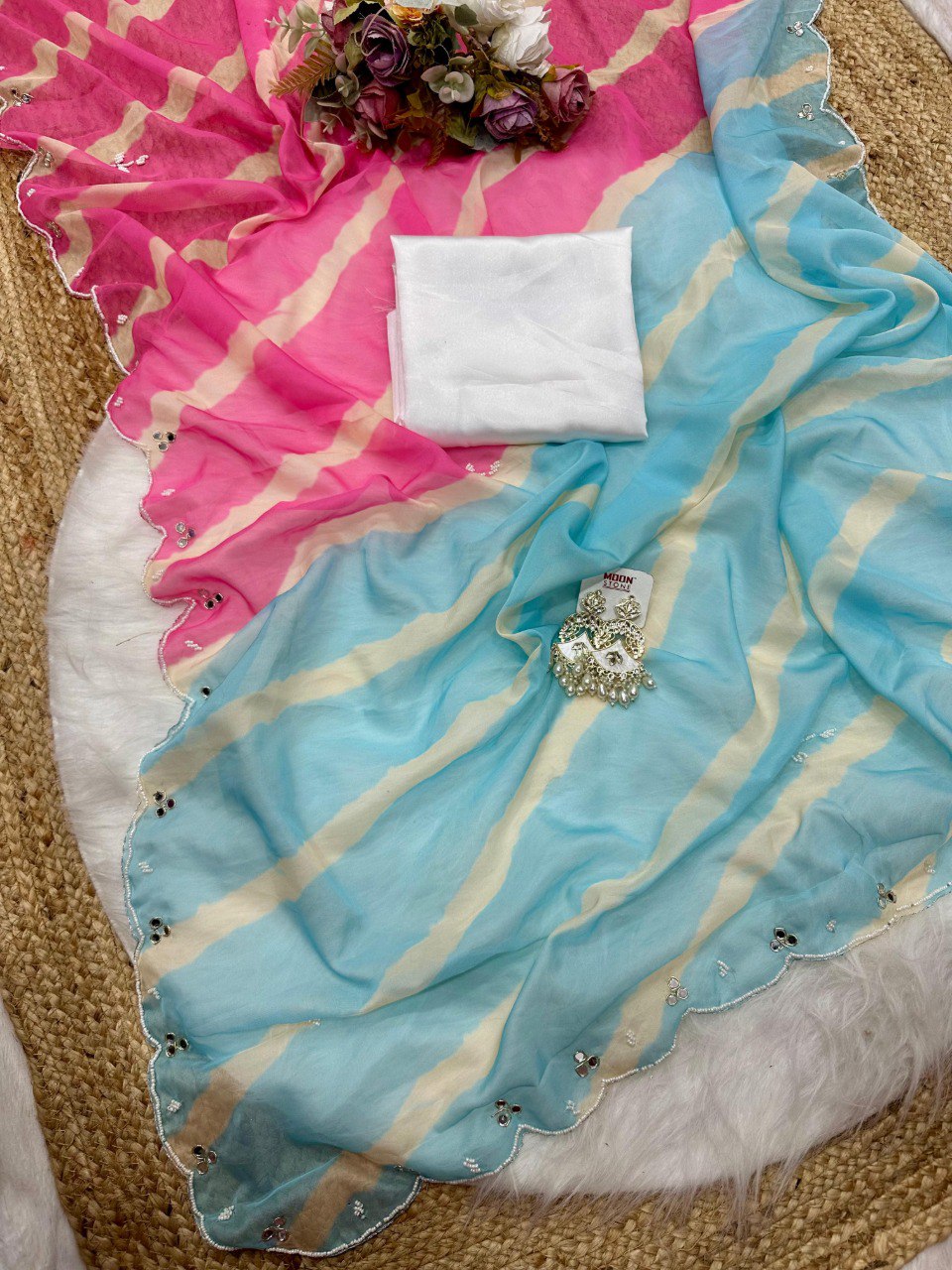 Bird's eye view of the elegant pink and blue Lehriya Tebi silk saree with hand-embroidered border and blouse.